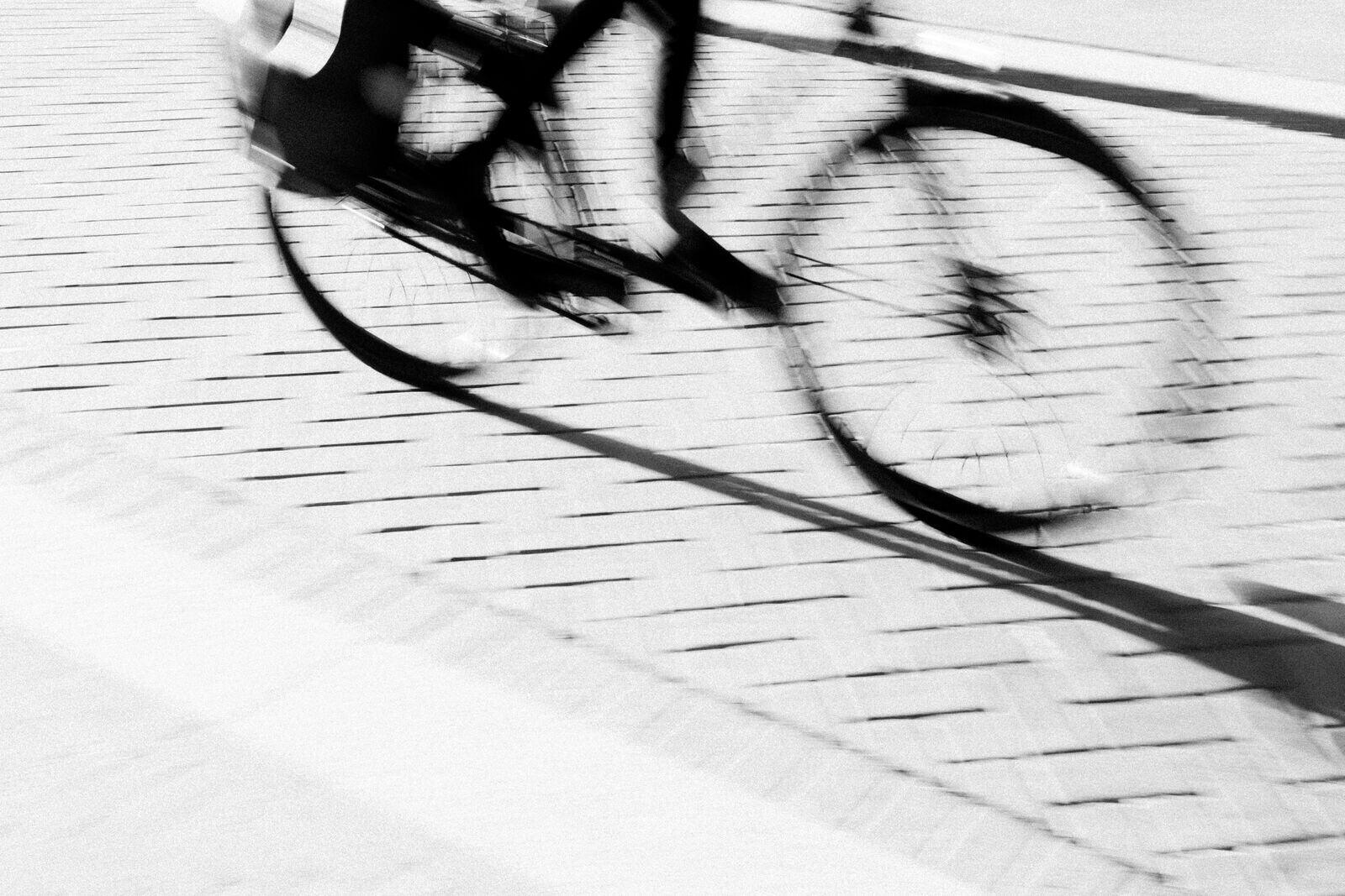 A bicycle in motion, blurred, on a cobbled street