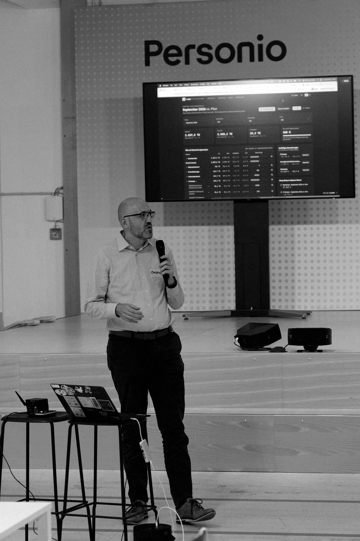 Controlling Workbench being presented on stage beneath the Personio sign in Munich