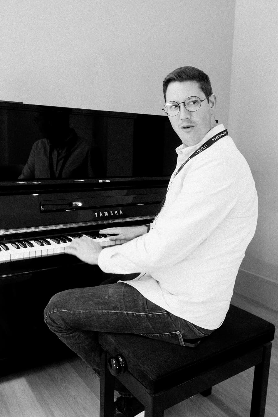 A teammate playing piano and glancing back at the camera