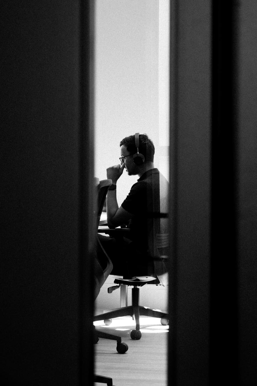 A teammate silhouetted at his desk, seen through a doorway