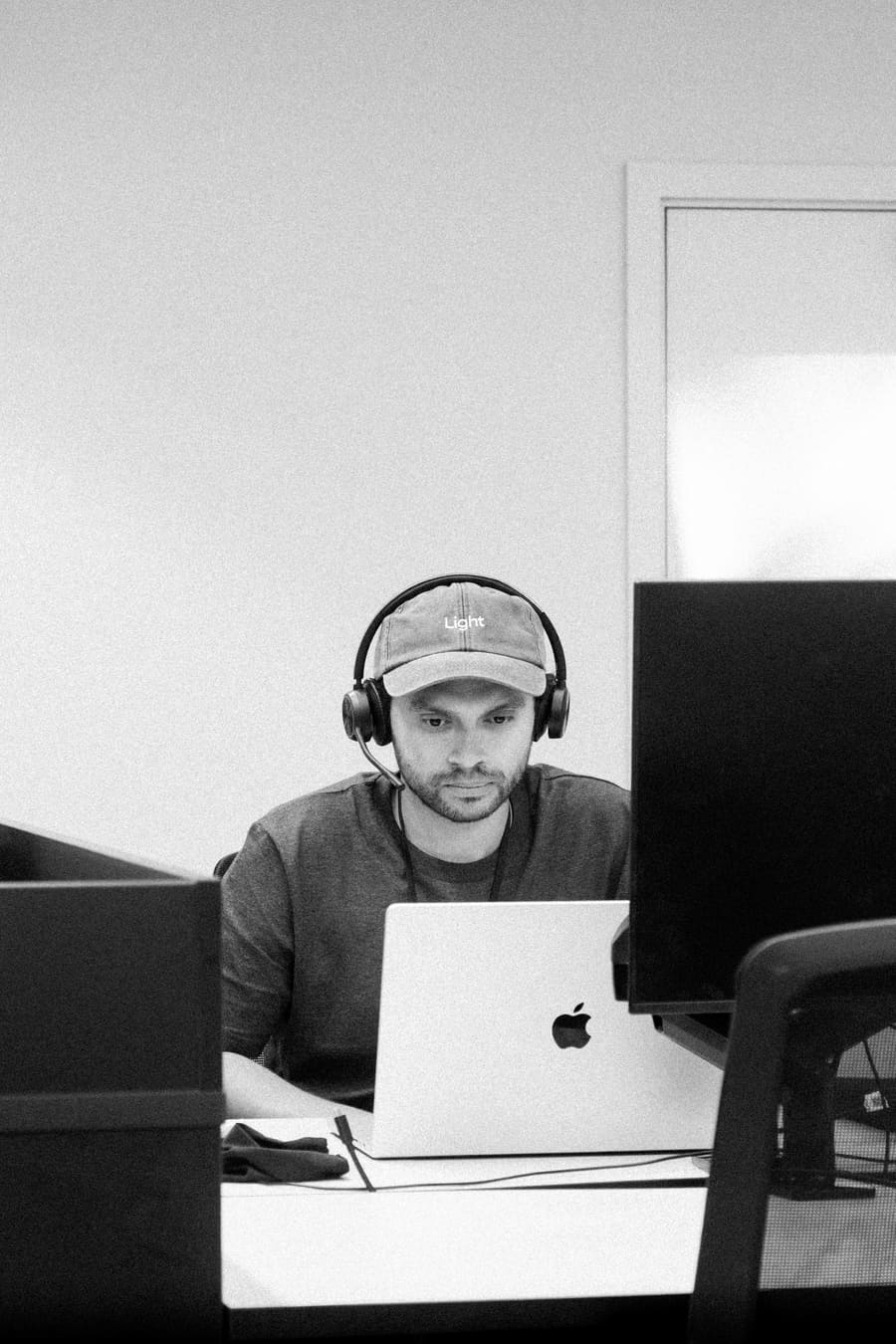 A teammate wearing a Light cap, working at his desk