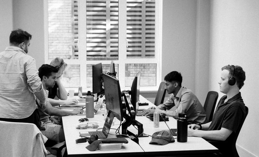 Teammates working together around a shared desk