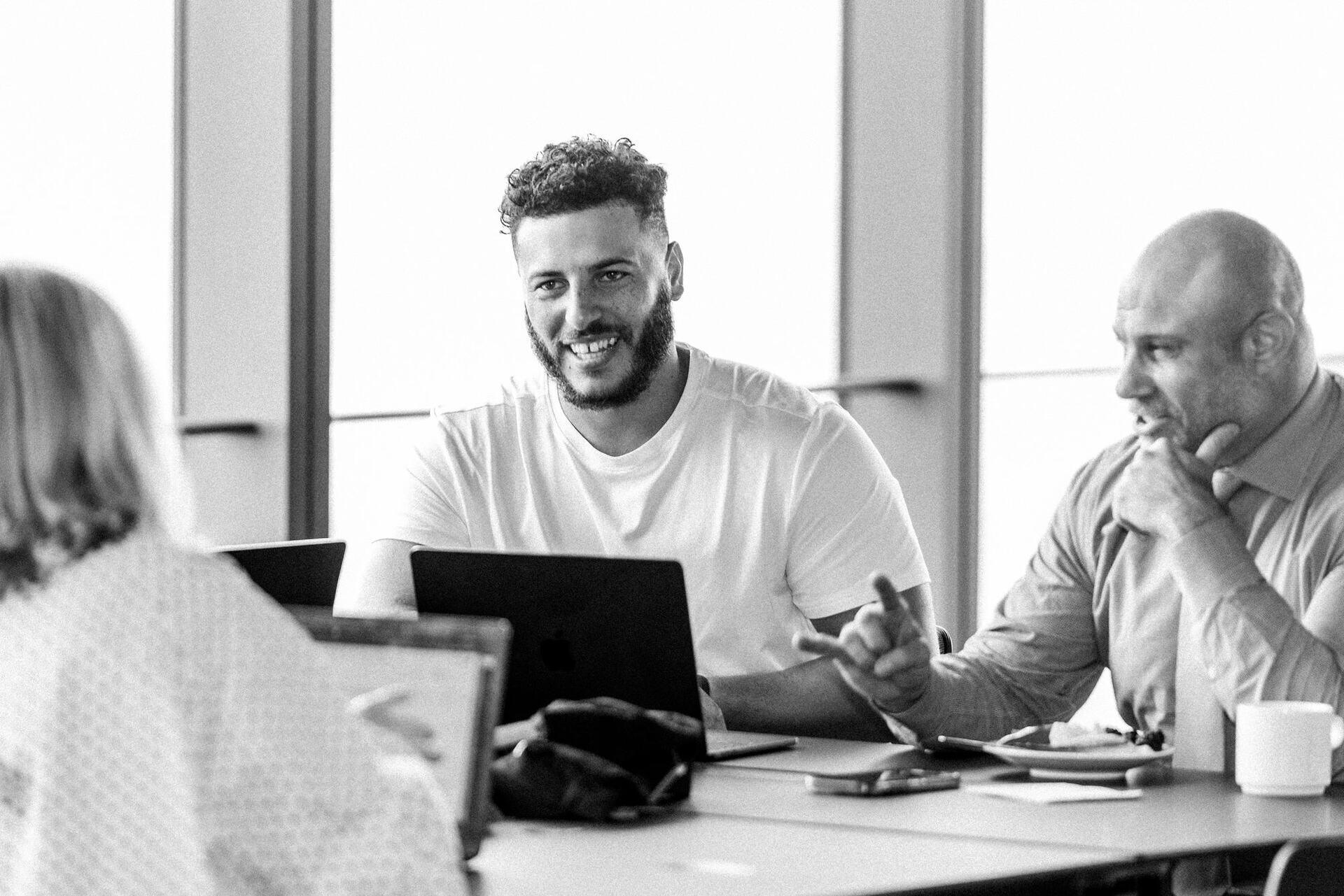 Two colleagues talking across a meeting table