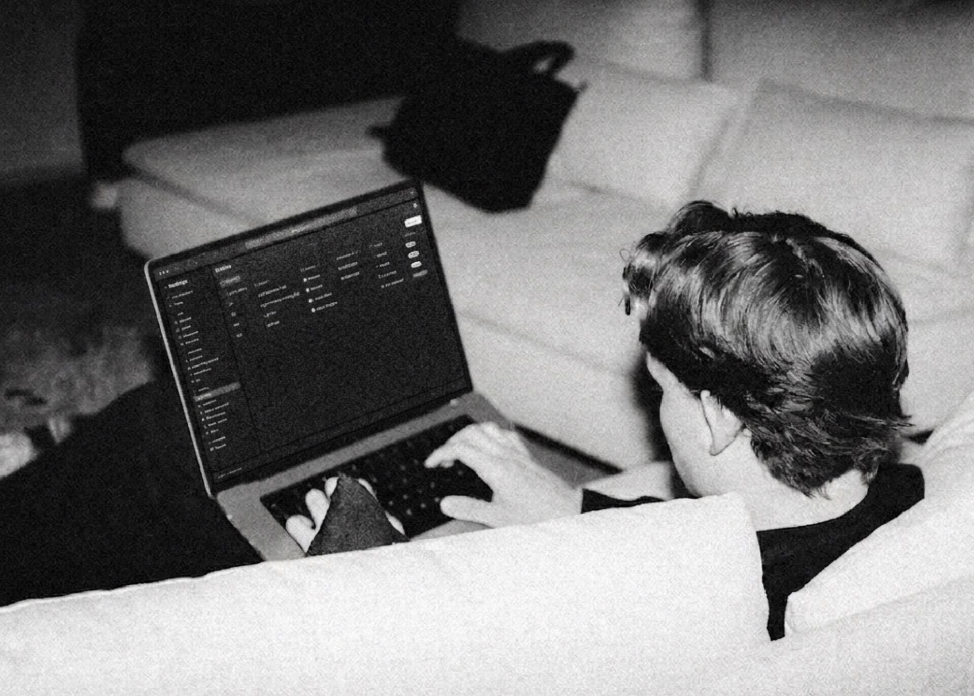 Someone working on a laptop on a sofa